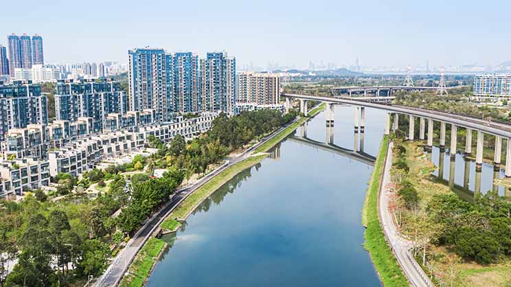 Rail over bridge on river with buildings on background