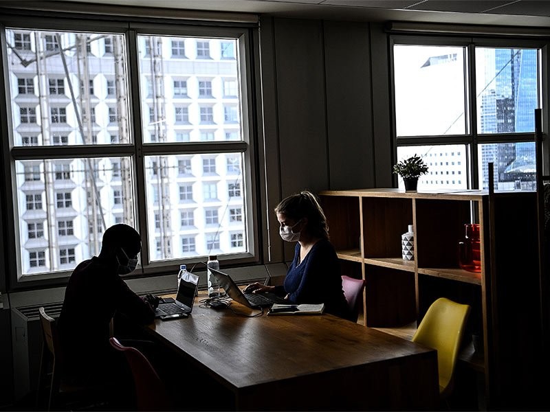 Two colleagues working on laptopn in the workplace